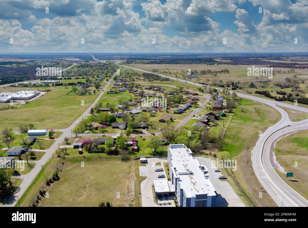 Vista aerea sopra lo svincolo di trasporto con trasporto del movimento dell'automobile Industria vicino quartiere residenziale a sviluppo suburbano con una Stroud Foto Stock