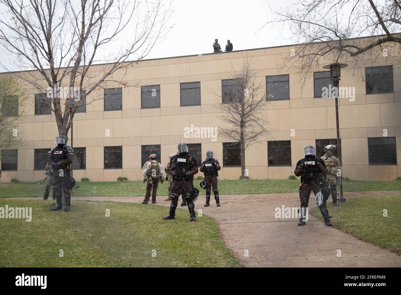 Brooklyn Center, Minnesota, Stati Uniti. 13 Apr 2021. 13 aprile 2021 - Brooklyn Center, Minnesota, USA: I deputati dello sceriffo della contea di Hennepin e la Guardia nazionale del Minnesota si trovano a guardia fuori dal Brooklyn Center Police Department durante le proteste, che continuano sull'uccisione della polizia di Daunte Wright. Wright, 20 anni, del Brooklyn Center, Minnesota, fu ucciso durante una sosta di Kim Potter, allora un ufficiale della polizia del Brooklyn Center. Brooklyn Center è un sobborgo immediatamente a nord di Minneapolis. Credit: Henry Pan/ZUMA Wire/Alamy Live News Foto Stock