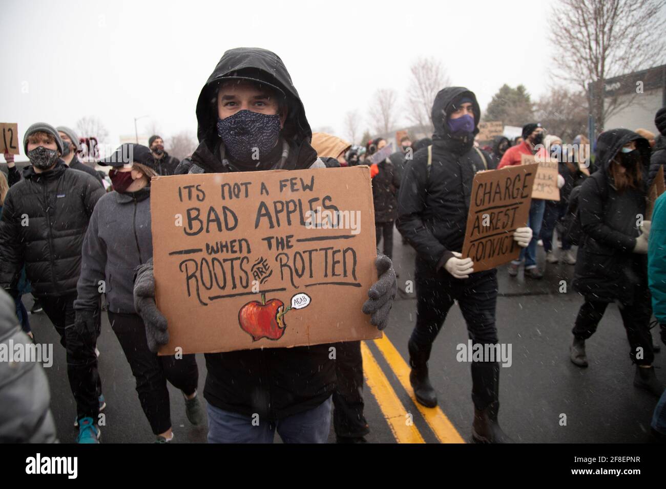 Brooklyn Center, Minnesota, Stati Uniti. 13 Apr 2021. 13 aprile 2021 - Brooklyn Center, Minnesota, USA: Una persona ha un cartello con la scritta ''non è un paio di mele cattive quando le radici sono marcio''' durante una marcia al Brooklyn Center Police Department. Continuano le proteste per l'uccisione della polizia di Daunte Wright. Wright, 20 anni, del Brooklyn Center, Minnesota, fu ucciso durante una sosta di Kim Potter, allora un ufficiale della polizia del Brooklyn Center. Brooklyn Center è un sobborgo immediatamente a nord di Minneapolis. Credit: Henry Pan/ZUMA Wire/Alamy Live News Foto Stock