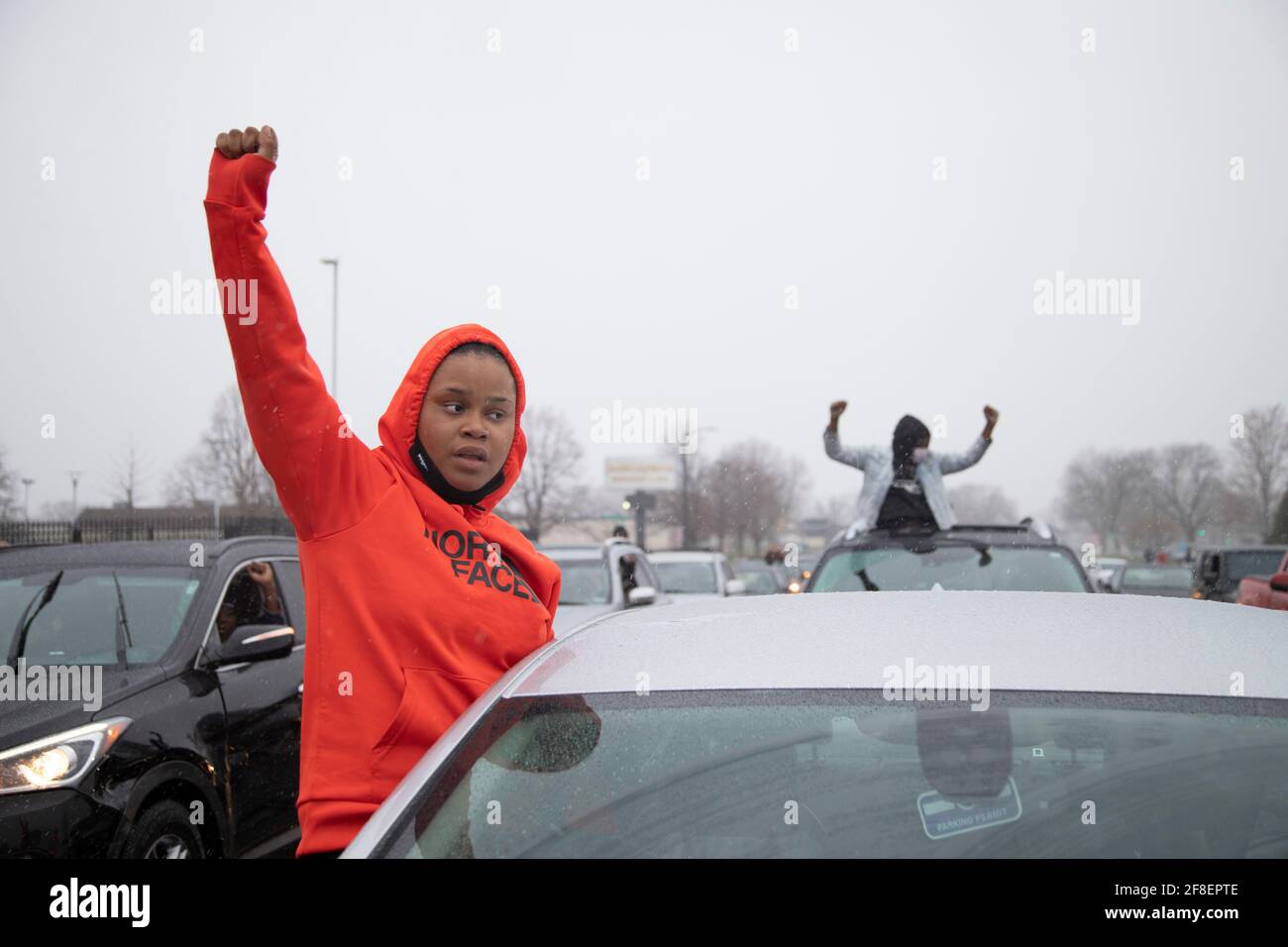 Brooklyn Center, Minnesota, Stati Uniti. 13 Apr 2021. 13 aprile 2021 - Brooklyn Center, Minnesota, USA: Le persone in automobili private tengono un pugno di potere nero durante una marcia al Brooklyn Center Police Department. Continuano le proteste per l'uccisione della polizia di Daunte Wright. Wright, 20 anni, del Brooklyn Center, Minnesota, fu ucciso durante una sosta di Kim Potter, allora un ufficiale della polizia del Brooklyn Center. Brooklyn Center è un sobborgo immediatamente a nord di Minneapolis. Credit: Henry Pan/ZUMA Wire/Alamy Live News Foto Stock