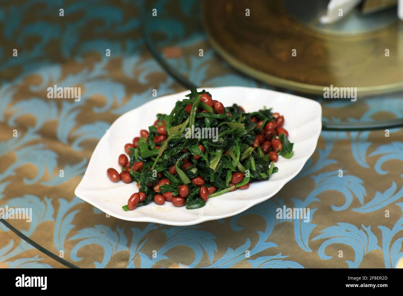 Antipasto di spinaci saltati con arachidi in un ristorante cinese Foto Stock