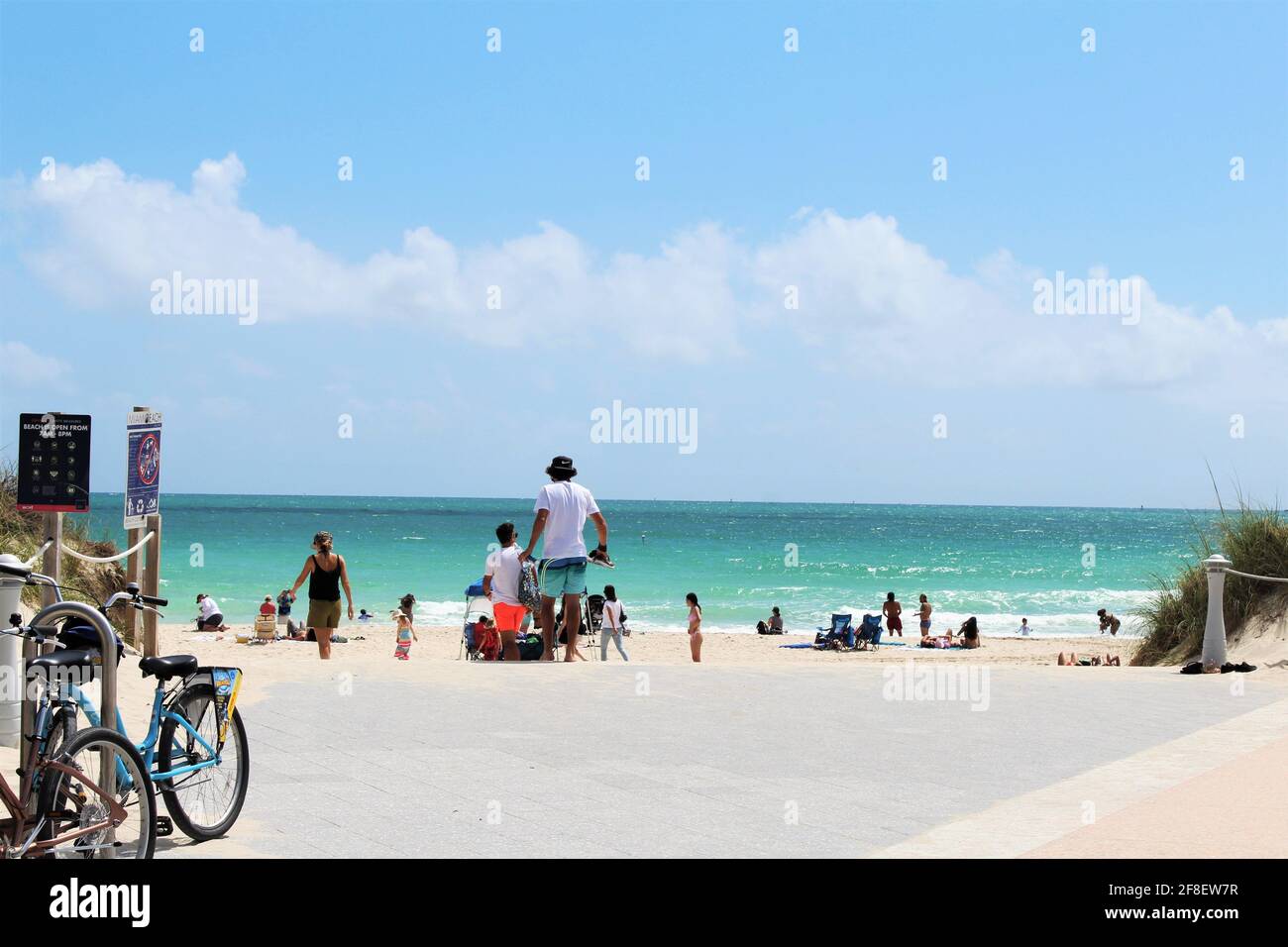 Biciclette parcheggiate all'ingresso della spiaggia. I turisti, le famiglie e gli spring breakers a South Pointe Beach a Miami Beach, Florida. Rottura della molla 2021 Foto Stock