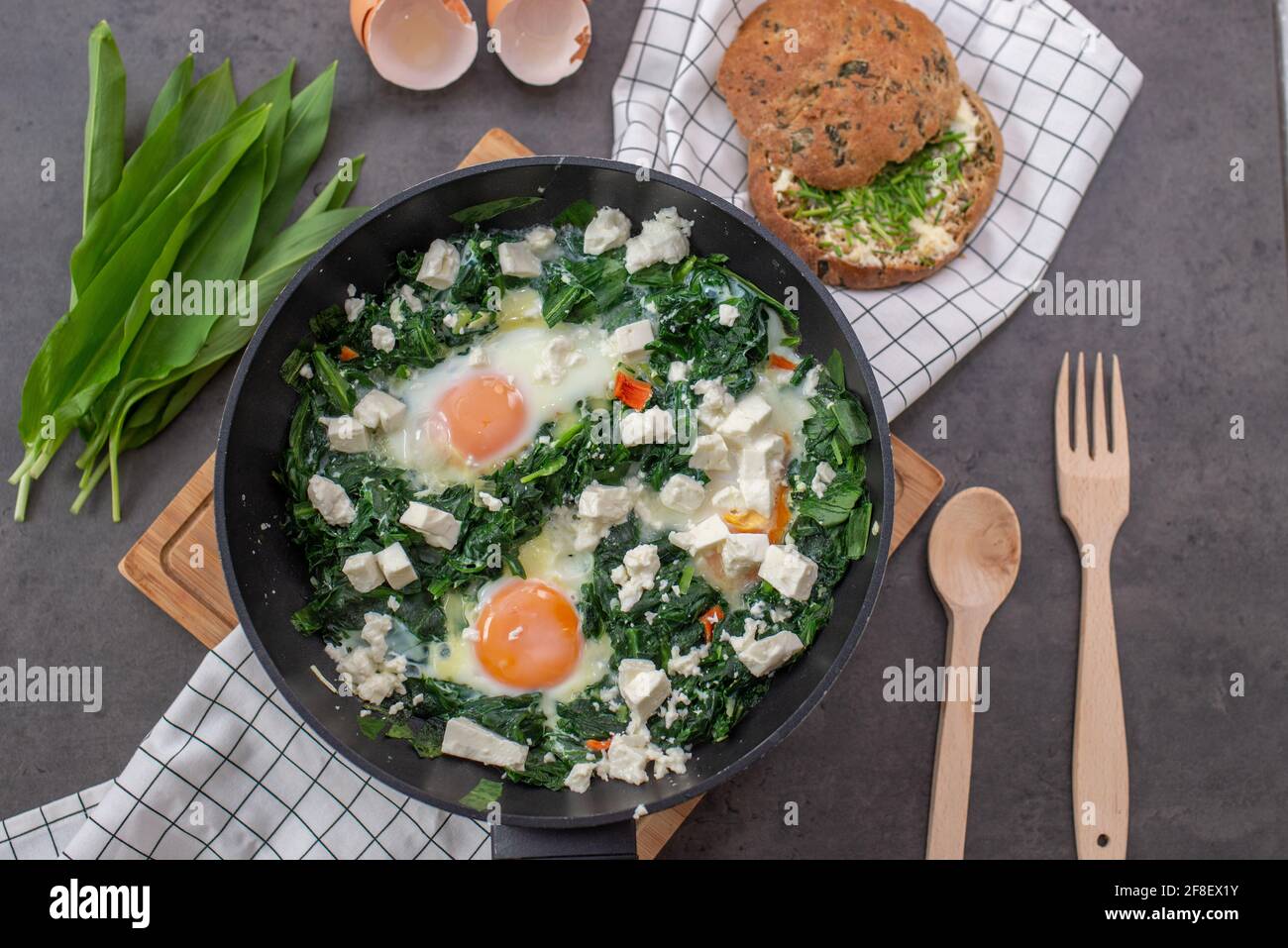 Shakshuka verde. Uova fritte con aglio selvatico e formaggio feta Foto Stock
