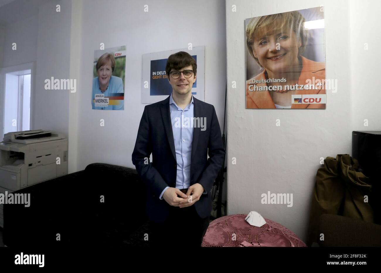 Grimmen, Germania. 11 Marzo 2021. Georg Günther, presidente della Junge Union Mecklenburg-Vorpommern, si trova nell'ufficio dell'associazione distrettuale della CDU, dietro di lui appendere vecchi manifesti elettorali di Angela Merkel. Günther è stato eletto il 26.02.2021 come candidato diretto della CDU nella precedente circoscrizione elettorale del Cancelliere Angela Merkel. In questa circoscrizione elettorale la Merkel aveva ottenuto il mandato diretto in tutte e otto le elezioni dal 1990. La Cancelliera aveva annunciato qualche tempo fa che non avrebbe più correre. Credit: Bernd Wüstneck/dpa-Zentralbild/dpa/Alamy Live News Foto Stock