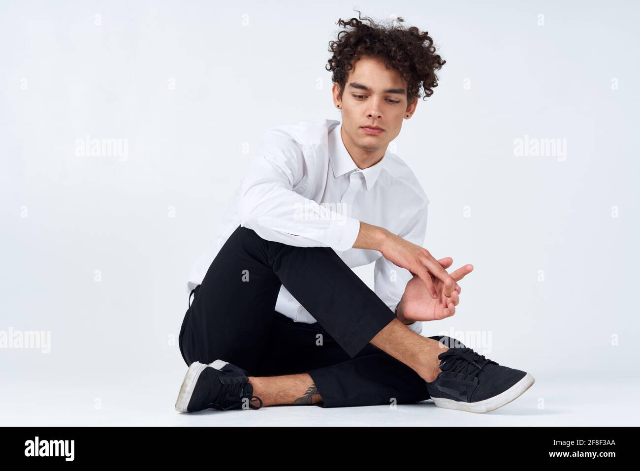 Adolescente in sneakers, pantaloni neri e una camicia bianca in una stanza  luminosa in piena crescita Foto stock - Alamy