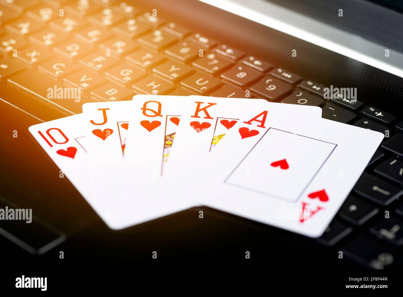 Piattaforma di gioco online, casinò e business di gioco d'azzardo. Carte da poker sulla tastiera del computer portatile. Foto Stock