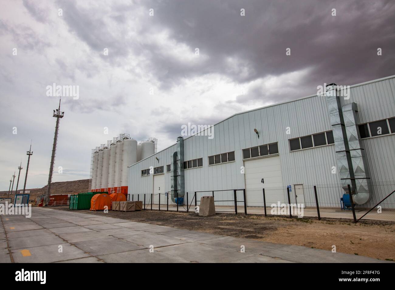 Mangystau, Kazakistan: Baia di Bautino. Terminal di carico sul Mar Caspio. Serbatoi di stoccaggio, edifici industriali (magazzino). Nuvole grigie. Foto Stock