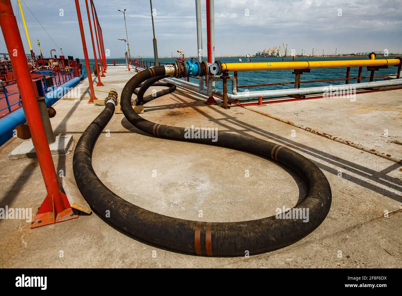 Aktau, Kazakhstan - Maggio 19 2012: Mar Caspio, terminal di carico gas. Tubo del gas in gomma (tubo flessibile). Porto marittimo di Aktau all'orizzonte. Foto Stock