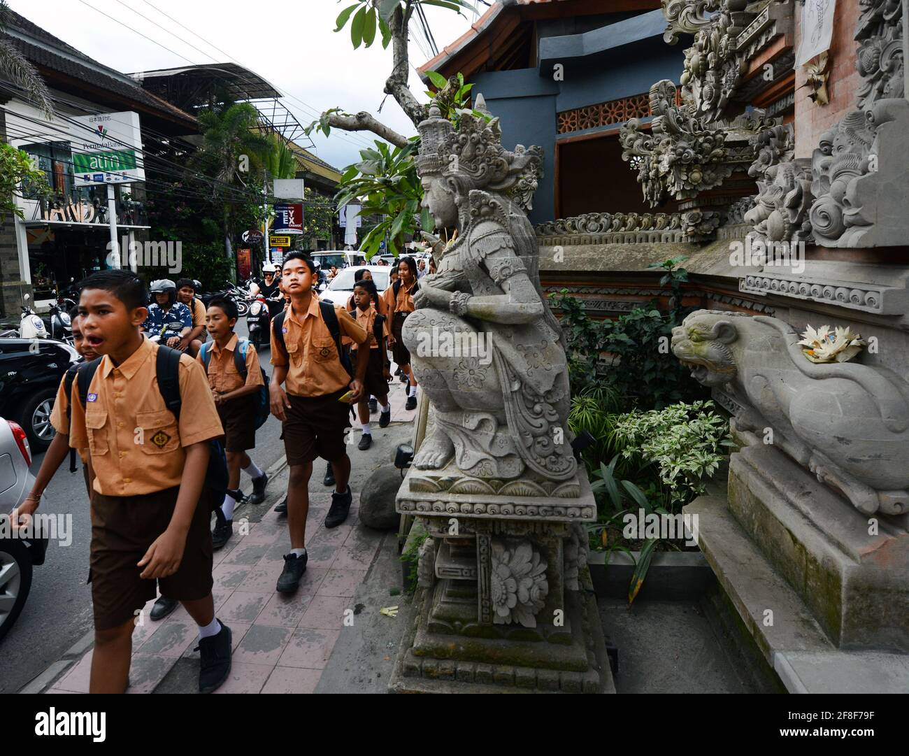 I bambini delle scuole balinesi camminano vicino al tempio di Sarasvati a Ubud, Bali, Indonesia. Foto Stock