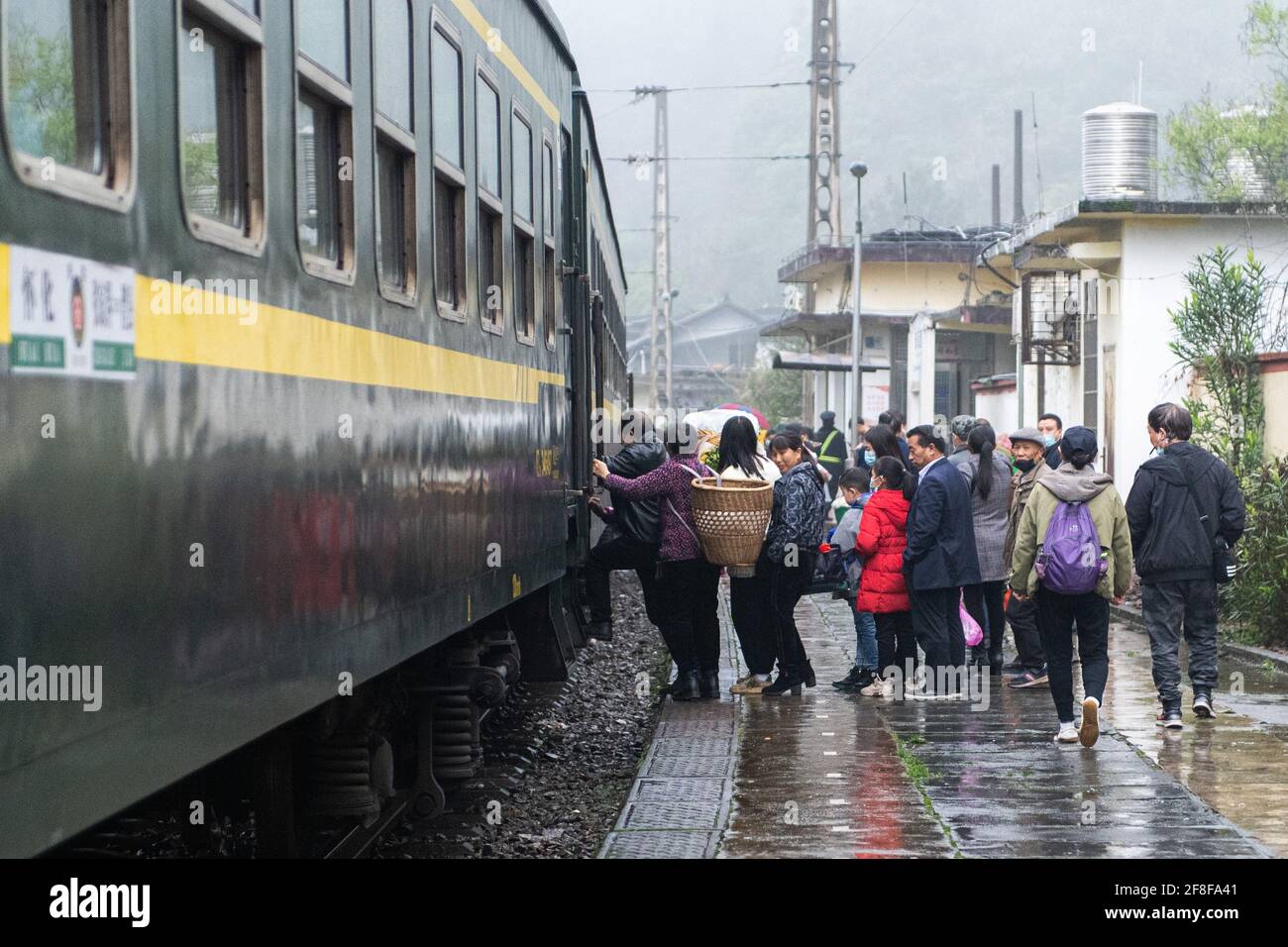 (210414) -- CHANGSHA, 14 aprile 2021 (Xinhua) -- passeggeri a bordo del treno 7266 presso la stazione di Dalongcun nella provincia di Hunan della Cina centrale, 11 aprile 2021. I treni 7265/7266/7267 iniziarono a funzionare nel 1995, estendendosi per più di 300 chilometri dalla stazione di Huaihua alla stazione di Lixian. I treni passano 37 fermate lungo la strada in 9 ore e 16 minuti. I prezzi dei biglietti variano da 1 yuan a 23.5 yuan (circa 0.15-3.59 dollari USA), che non sono stati aumentati in 26 anni. I treni attraversano le montagne di Wuling. Grazie a loro, gli abitanti del villaggio non solo possono trasportare frutta, verdura e altre loca Foto Stock