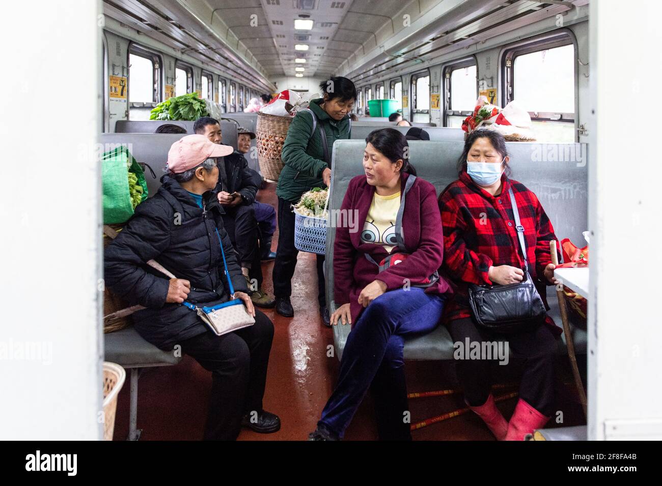 (210414) -- CHANGSHA, 14 aprile 2021 (Xinhua) -- i passeggeri parlano sul treno 7266 nella provincia di Hunan della Cina centrale, 11 aprile 2021. I treni 7265/7266/7267 iniziarono a funzionare nel 1995, estendendosi per più di 300 chilometri dalla stazione di Huaihua alla stazione di Lixian. I treni passano 37 fermate lungo la strada in 9 ore e 16 minuti. I prezzi dei biglietti variano da 1 yuan a 23.5 yuan (circa 0.15-3.59 dollari USA), che non sono stati aumentati in 26 anni. I treni attraversano le montagne di Wuling. Grazie a loro, gli abitanti del villaggio non solo possono portare frutta, verdura e altri prodotti locali fuori per Foto Stock