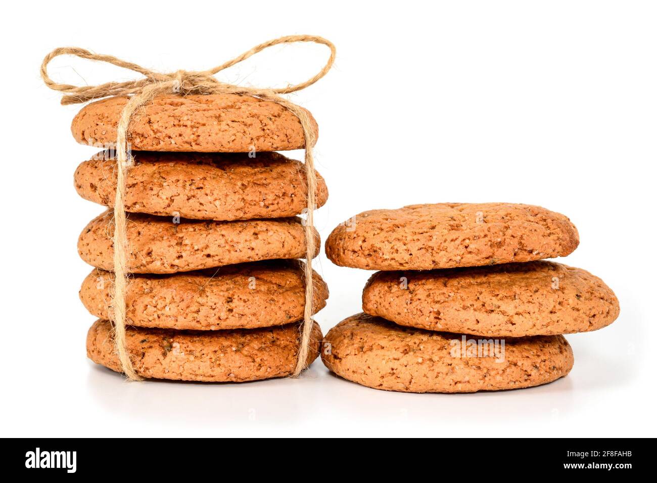 Biscotti fatti in casa. Cinque biscotti dolci fatti con farina d'avena, accatastati e legati con corda di lino in stile rustico e tre successivi. Gustoso biscotto in alta re Foto Stock