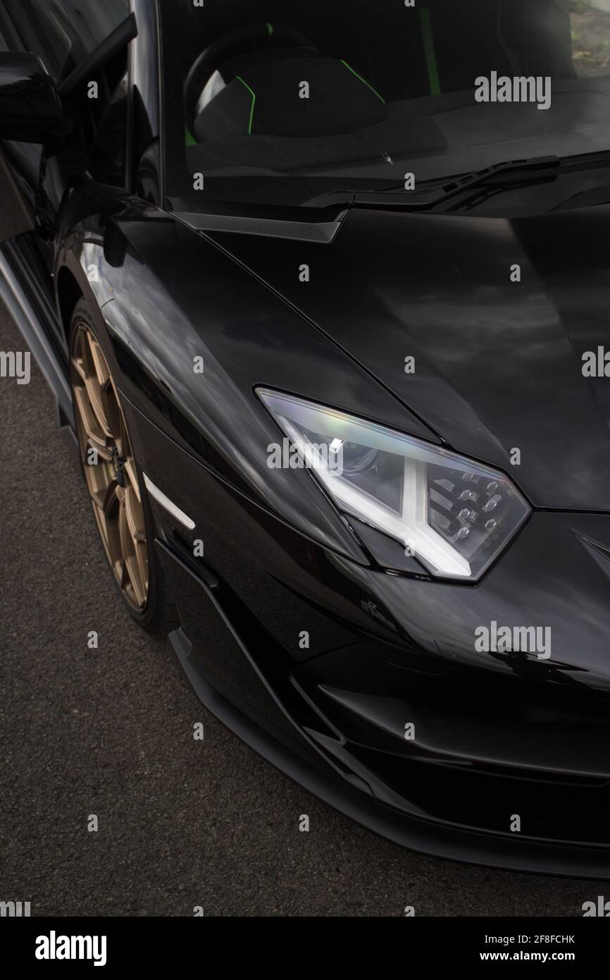 Un pannello laterale anteriore 2020 Lamborghini Aventador SVJ nero con Cerchi in lega oro e fari a LED con aerodinamica anteriore Foto Stock