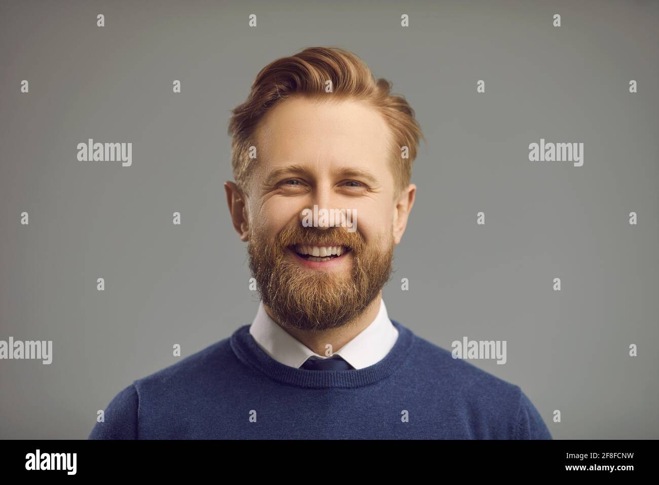 Studio ritratto di uomo felice con barba folta, baffi e sorriso amichevole positivo Foto Stock