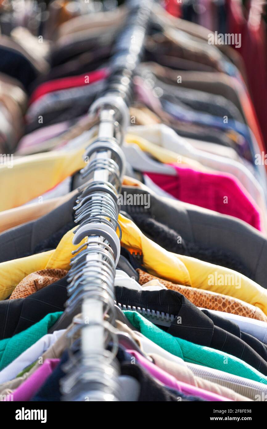 Abiti diversi sul supporto. Stile di vita sostenibile, cambio di moda, seconda mano, moda lenta. Primo piano Foto Stock