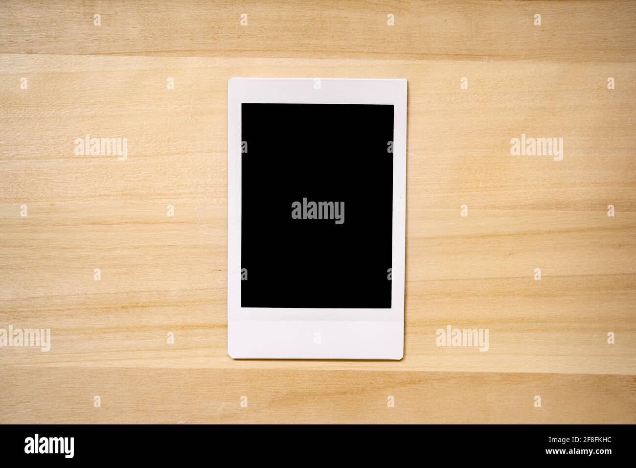 cornice fotografica istantanea su sfondo legno Foto Stock
