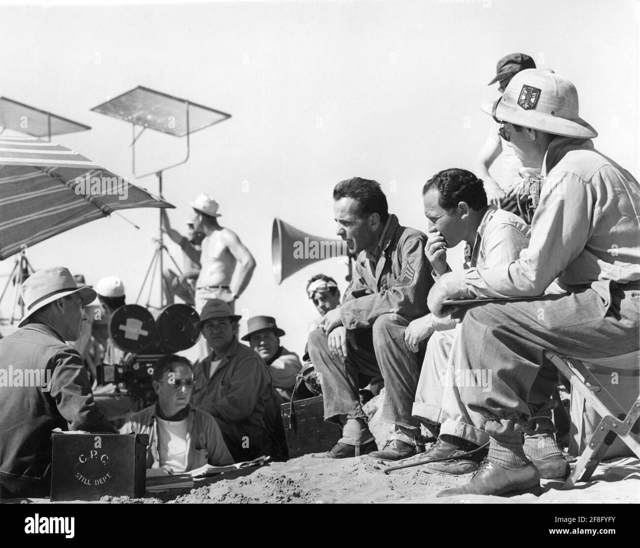 Direttore ZOLTAN KORDA (estrema sinistra) HUMPHREY BOGART e accanto a lui Assistente Direttore ABBY BERLIN Sul set location cantato con Film Crew durante la ripresa di LA sceneggiatura del regista SAHARA 1943 ZOLTAN KORDA e John Howard Lawson Zoltan Korda basato su incidente dal film sovietico il tredici Musica Miklos Rozsa Columbia immagini Foto Stock