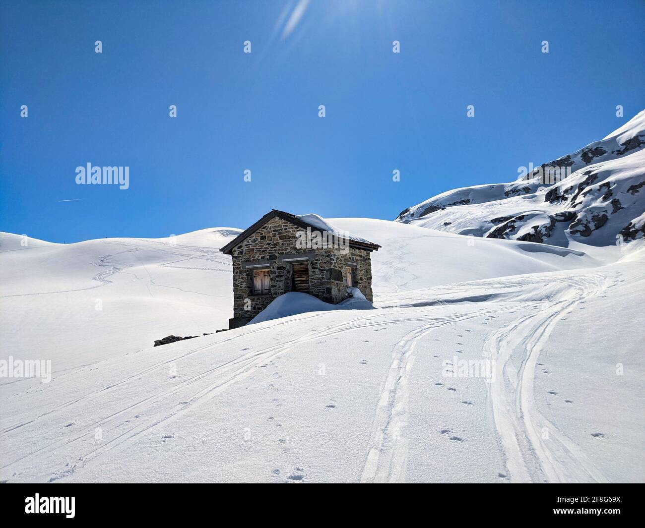 vecchia capanna doganale tra il confine austriaco e svizzero sul passavite del plasseggenpass. Tour di sci soleggiato in montagna. Cielo blu Foto Stock
