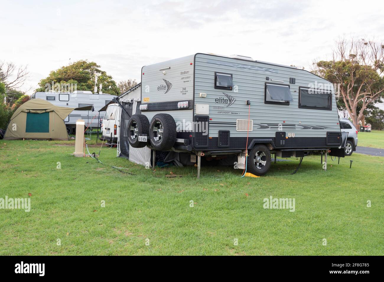 Caravan e una tenda al mattino presto a Merimbula NRMA Caravan Park sulla costa sud del New South Wales Dell'Australia Foto Stock