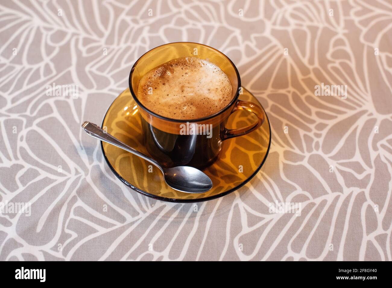 Caffè nero con schiuma in una tazza Duralex. Tazza Duralex e piattino. Foto Stock