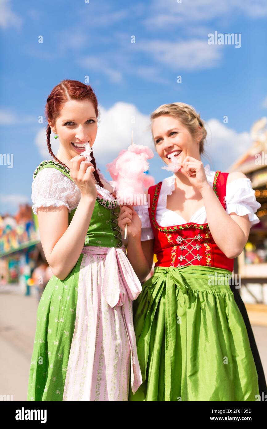 Giovani donne in tradizionali abiti bavarese - dirndl o tracht - con zucchero filato su un festival o Oktoberfest Foto Stock