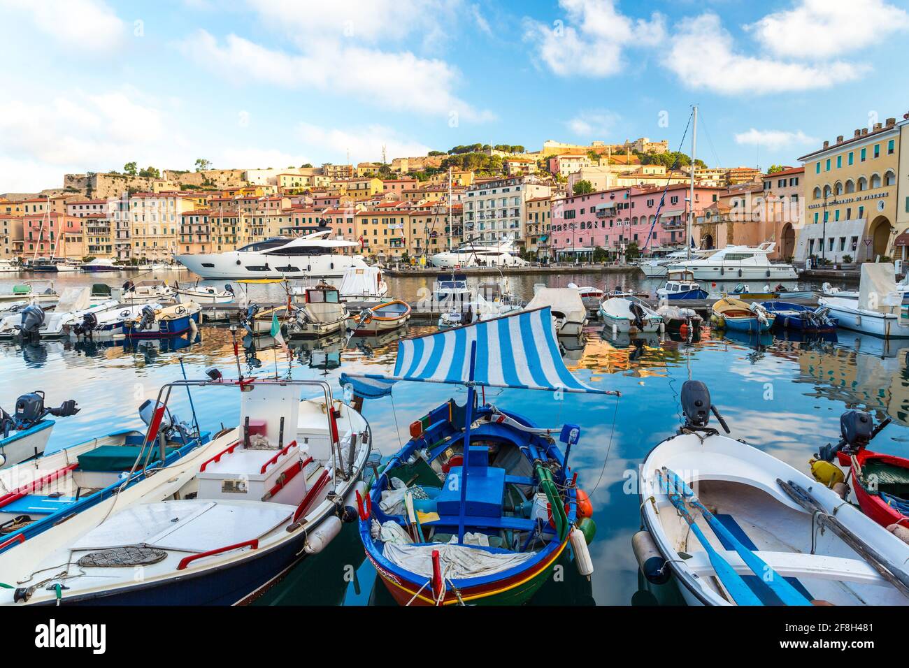 Porto di Portoferraio, barche ormeggiate vicino e gli edifici sulla collina Foto Stock