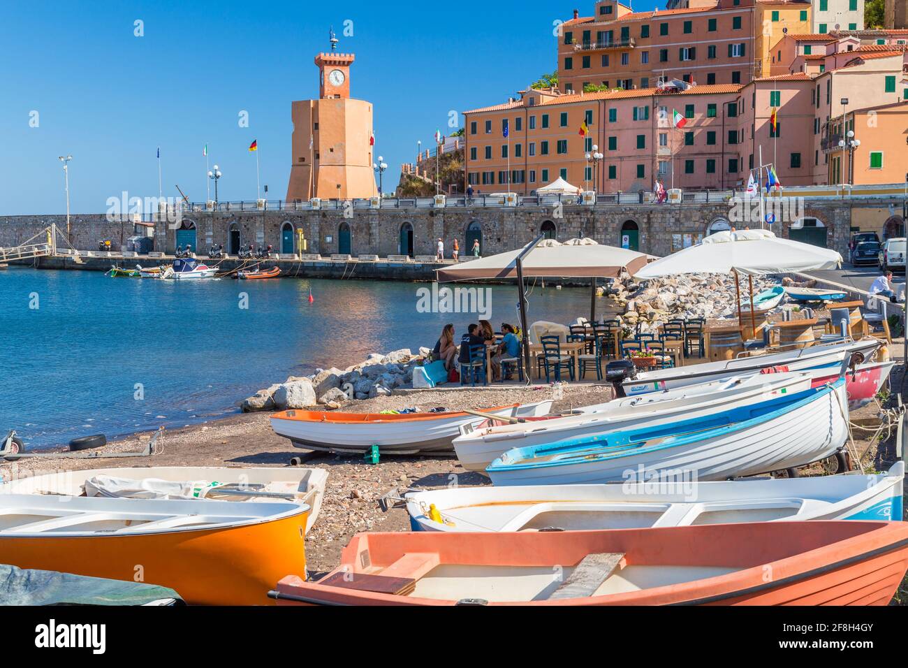 Porto di Rio Marina, sull'Isola d'Elba, edifici storici e barche da pesca ormeggiate nel porto. Foto Stock