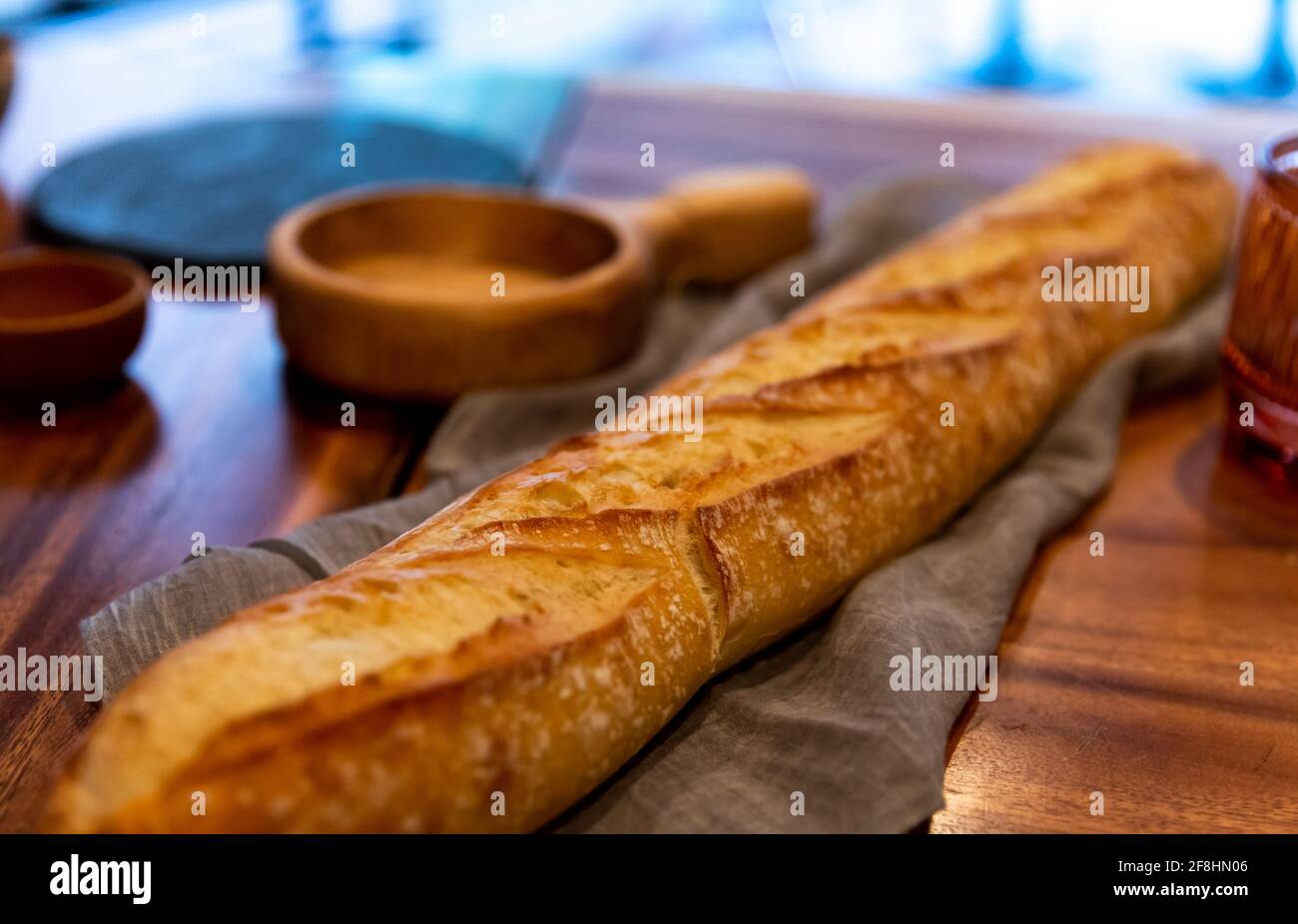 pane lungo su un bancone di legno con una texture morbida tessuto sotto Foto Stock
