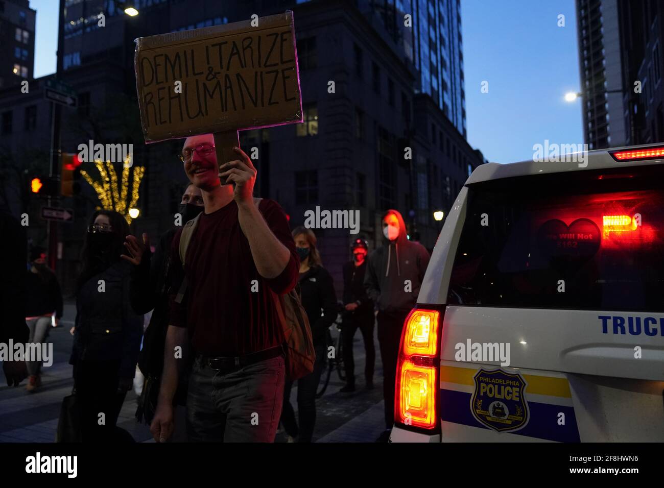 Philadelphia, Stati Uniti. 13 Apr 2021. Un dimostratore tiene un cartello accanto ad una macchina della polizia di Philadelphia durante una protesta di Justice for Daunte Wright a Philadelphia, USA. Daunte Wright era un uomo nero di 20 anni che fu ucciso e ucciso da un agente di polizia a Brooklyn Center, Minnesota, il 11 aprile. Credit: Chase Sutton/Alamy Live News Foto Stock