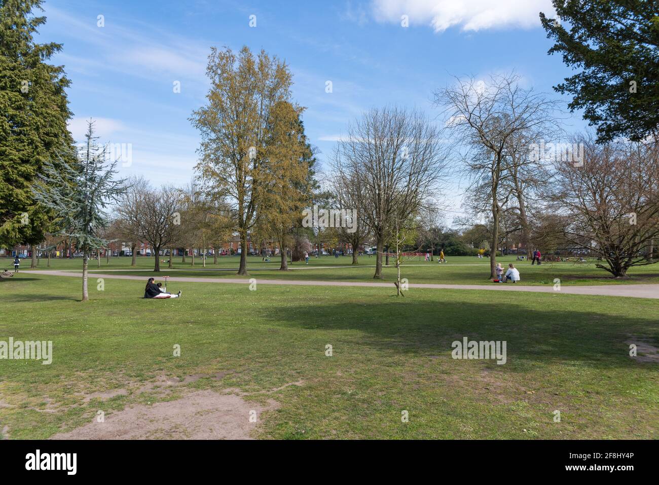 Persone che godono di sole condizioni meteorologiche di primavera a Kings Heath Park, Kings Heath, Birmingham, Regno Unito Foto Stock