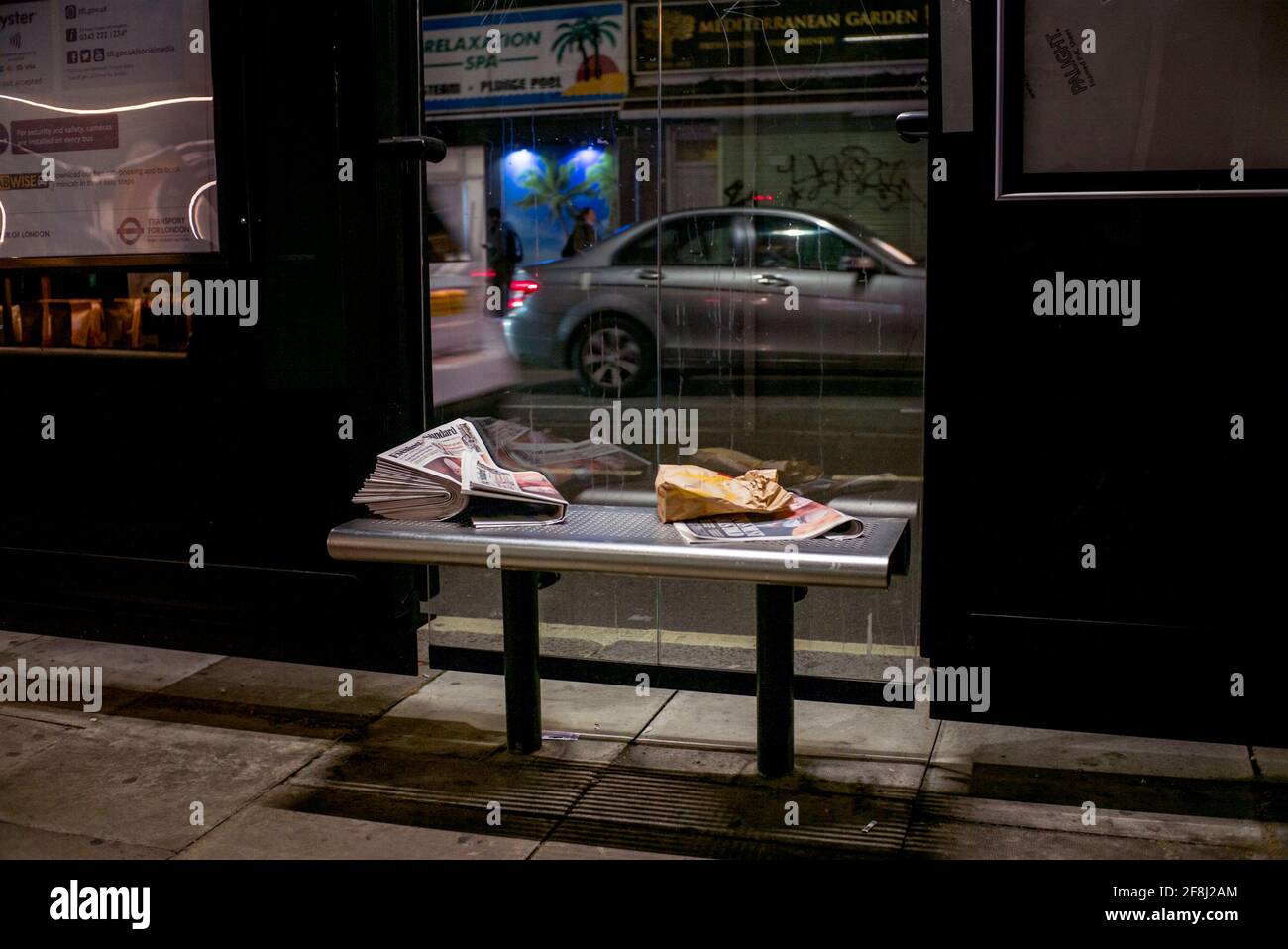 i giornali sono andati a sinistra ad una fermata dell'autobus, cucciolata sulla panchina Foto Stock
