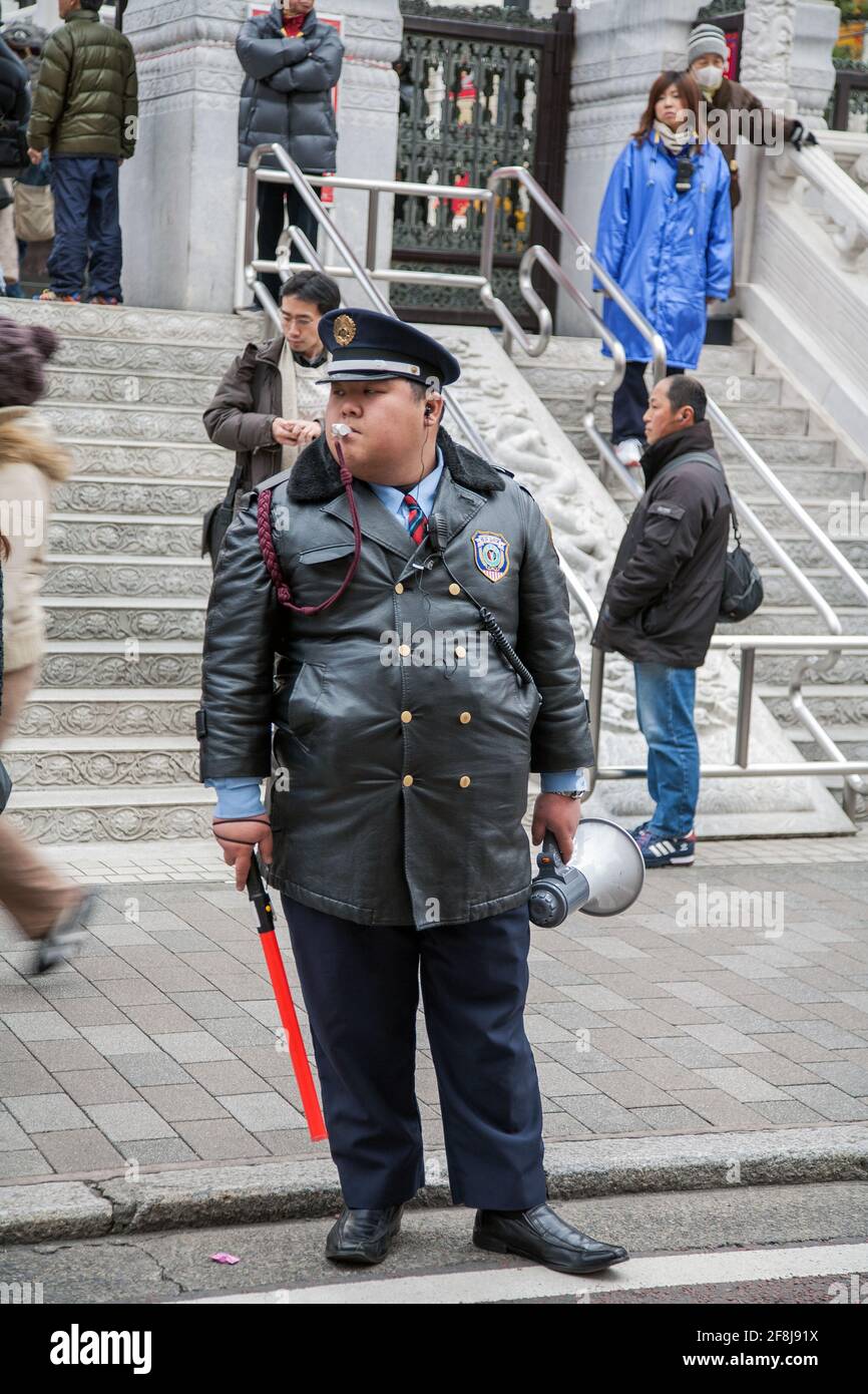 Guardia di sicurezza giapponese sovrappeso sul marciapiede fuori dal tempio Kanteibyo (Kuan ti Miao), Chinatown, Yokohama, Giappone Foto Stock