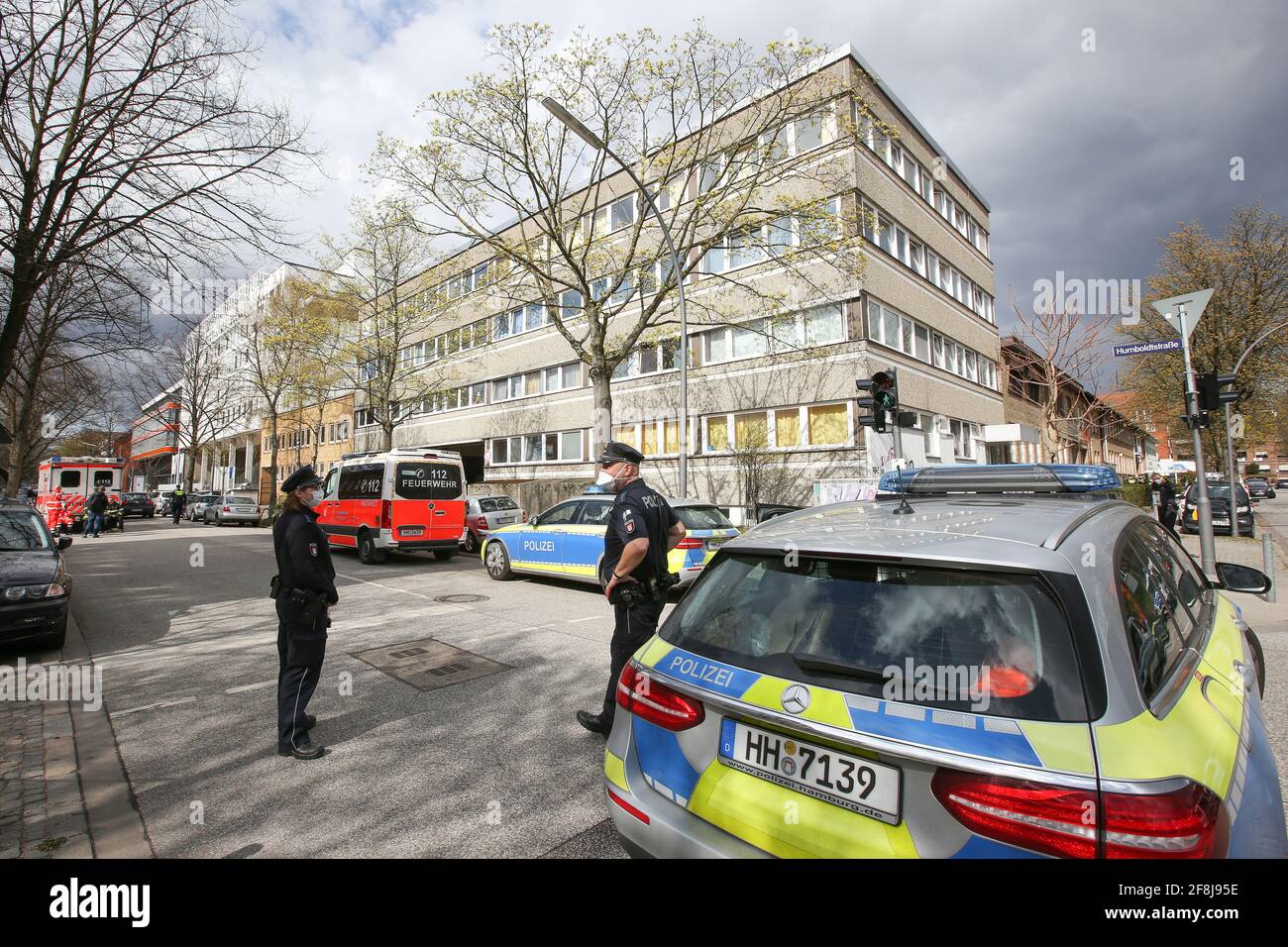 14 aprile 2021, Amburgo: Polizia e vigili del fuoco si trovano su una strada chiusa durante un'operazione presso un rifugio per rifugiati. A causa della possibile minaccia di due bambini, mercoledì sono state dispiegate forze speciali della polizia di Amburgo in un rifugio per rifugiati nel distretto di Barmbek. Secondo la polizia, una madre e i suoi due figli, di tre e sei anni, si erano barricati in una stanza perché i più piccoli dovevano essere presi in cura. Ci sono stati segnali di una situazione minacciosa. I 41 anni potrebbero essere stati armati di un coltello, ha detto. Dopo cinque ore, la porta è stata aperta e il Foto Stock