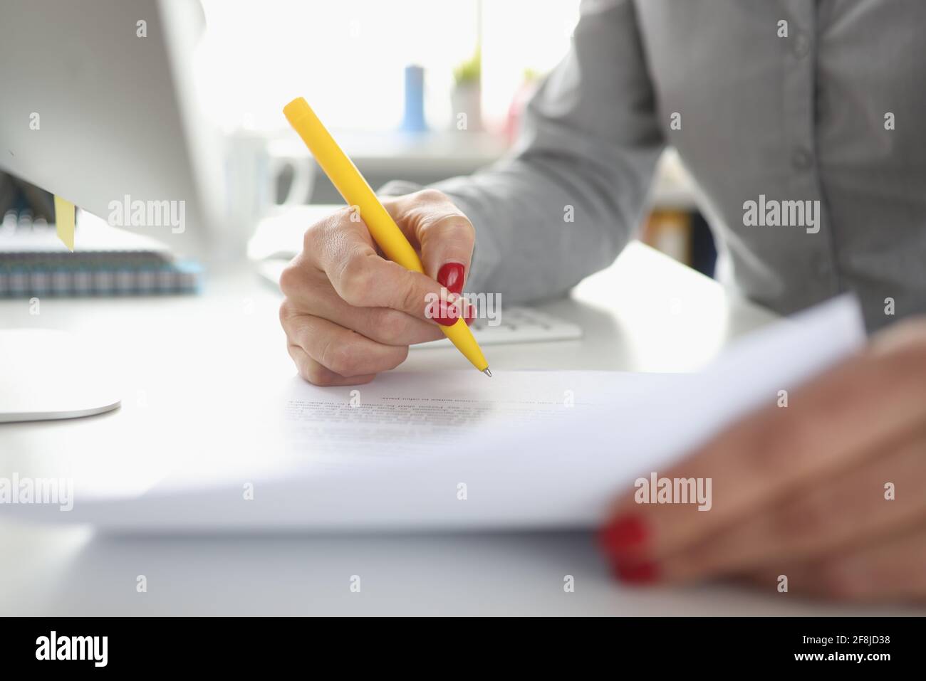 La mano della donna tiene il documento della penna e dei segni Foto Stock