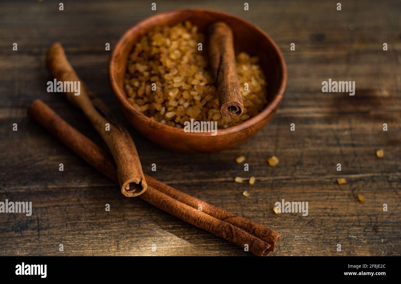 Ciotola con zucchero di canna e bastoncini di cannella Foto Stock