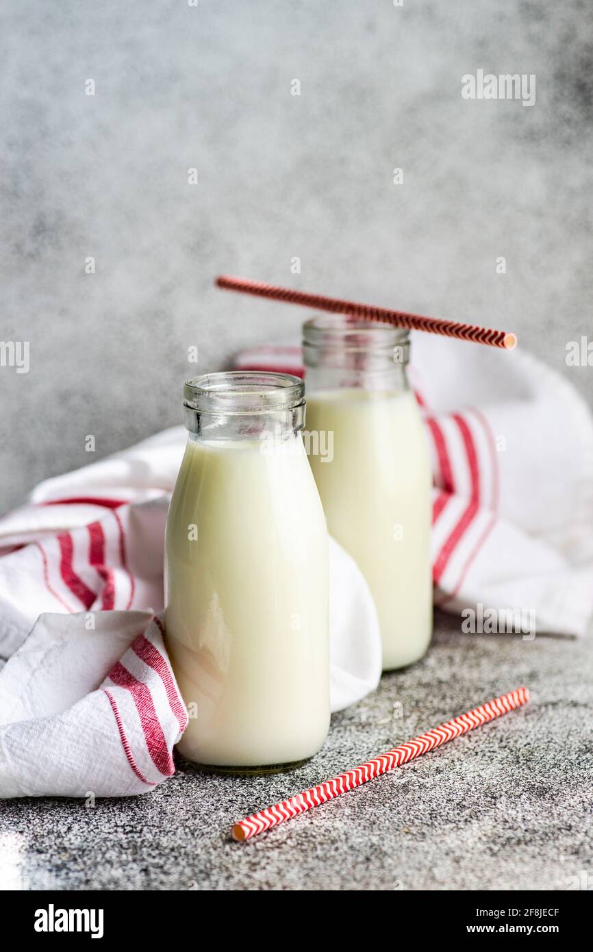 Due bottiglie di latte e cannucce da bere sul tavolo successivo ad un  tovagliolo Foto stock - Alamy