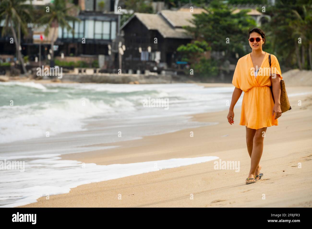Donna che cammina lungo la spiaggia sull'isola tropicale di Koh Phangan Foto Stock
