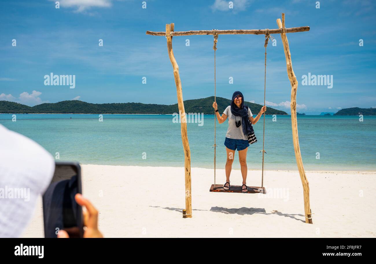 donna che usa swing in una visita a tropicale l'isola Di Koh Madsum Foto Stock