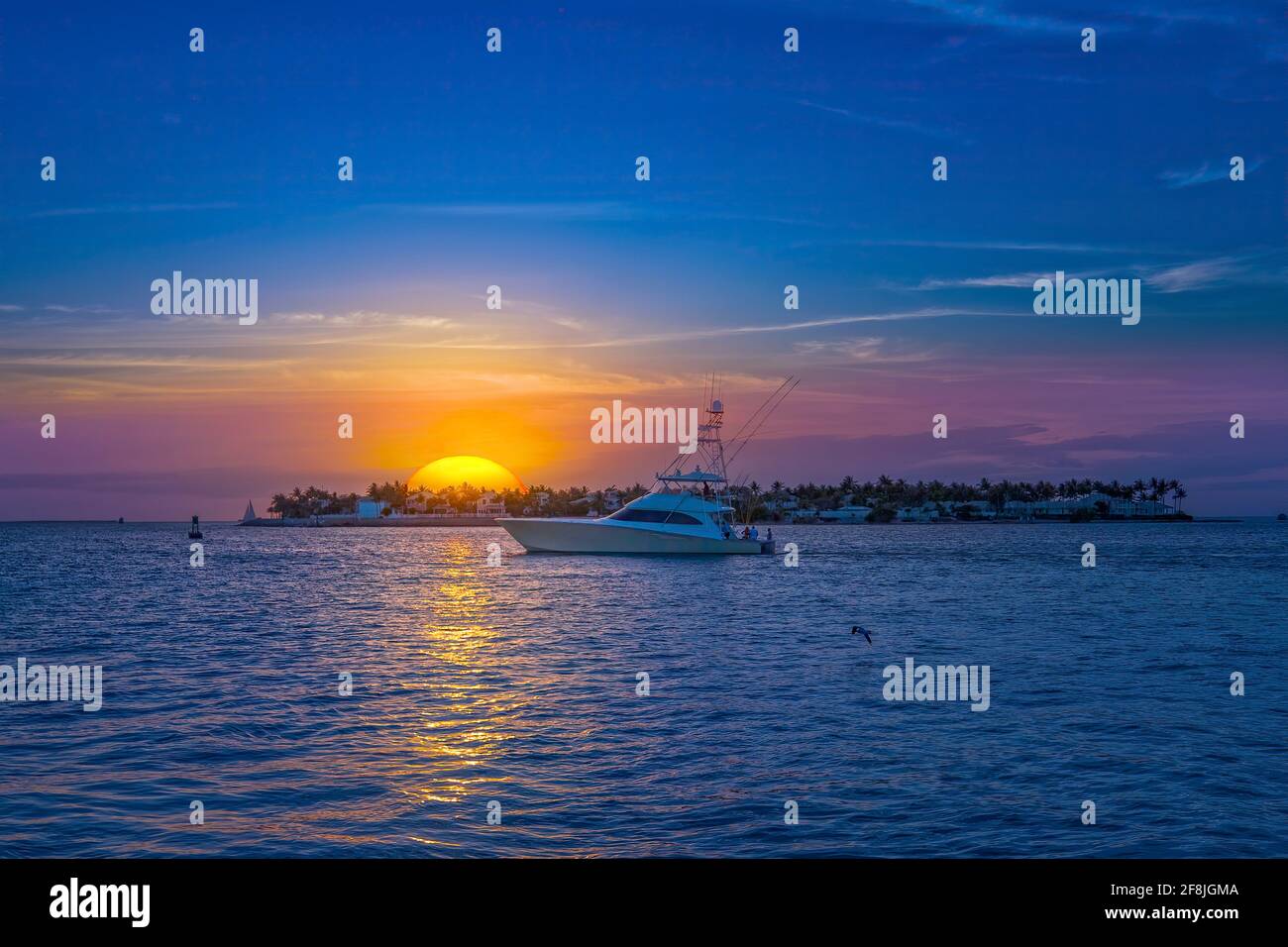 Uno yacht veleggia sotto il sole che tramonta a Key West, Florida. Foto Stock