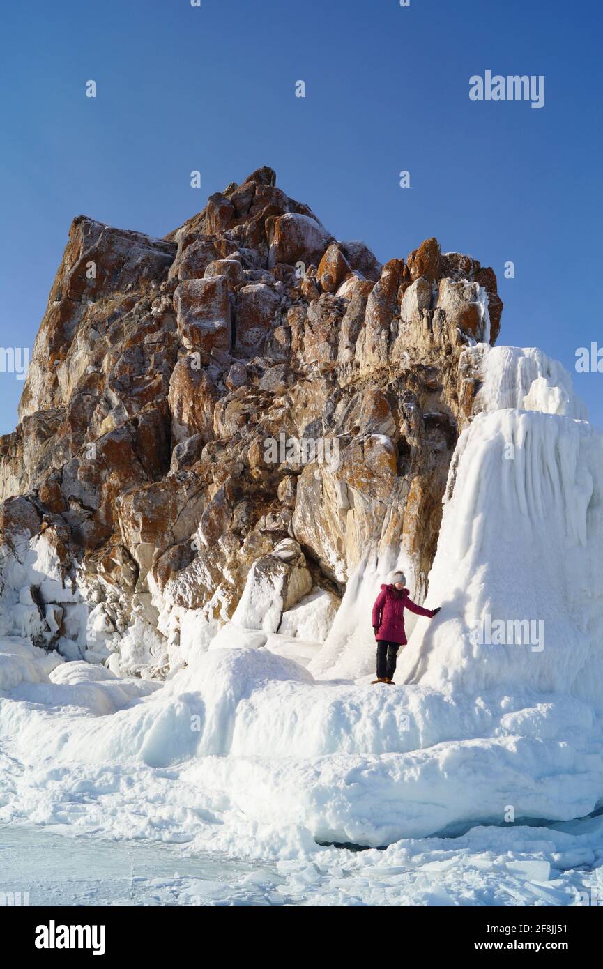 Vista della roccia ghiacciata Shamanka e la ragazza in piedi sul ghiaccio Foto Stock