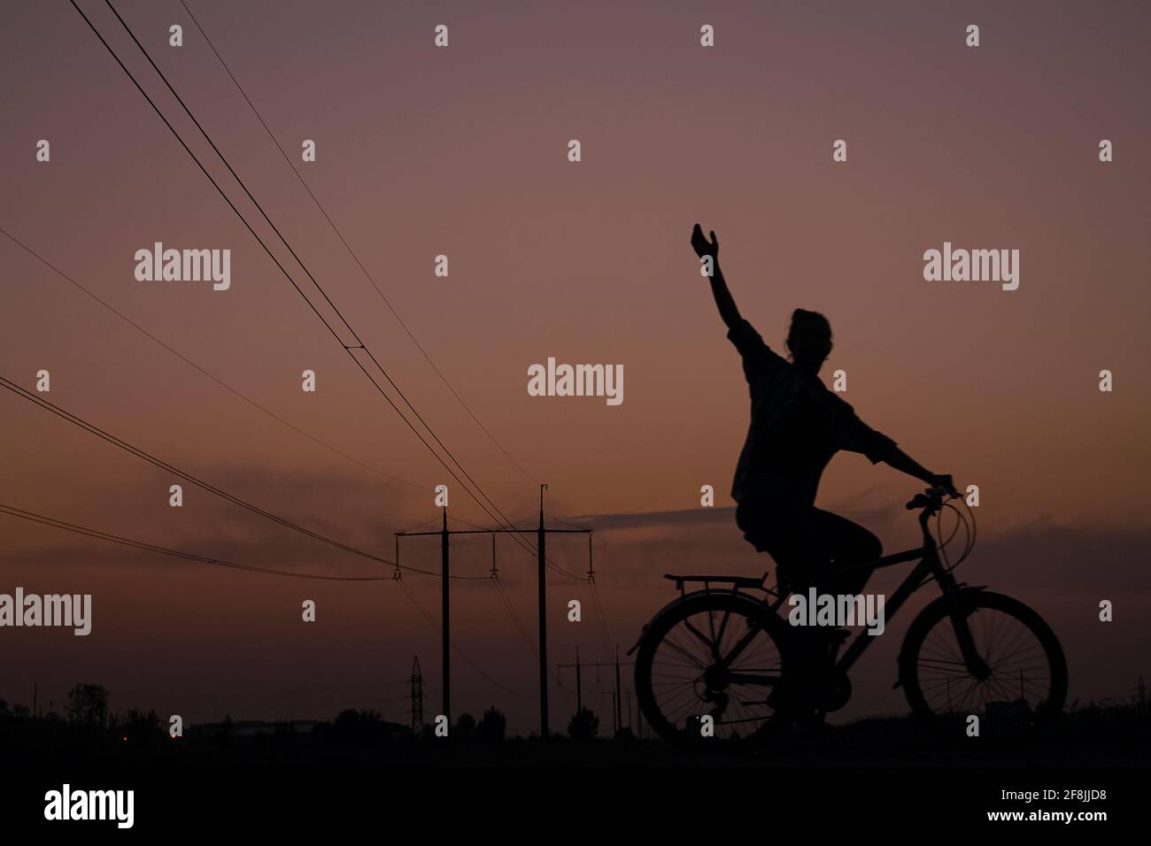 Passeggiata serale di una ragazza al tramonto in bicicletta in viaggio Foto Stock