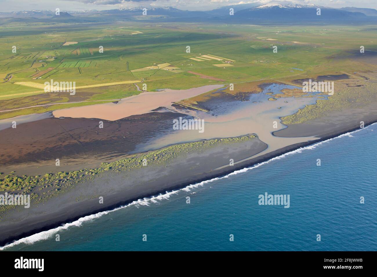 Vista aerea su Landeyjarsandur che mostra la spiaggia con sabbia vulcanica nera e acqua marrone carico di sedimenti che fluiscono in mare in estate, Islanda Foto Stock