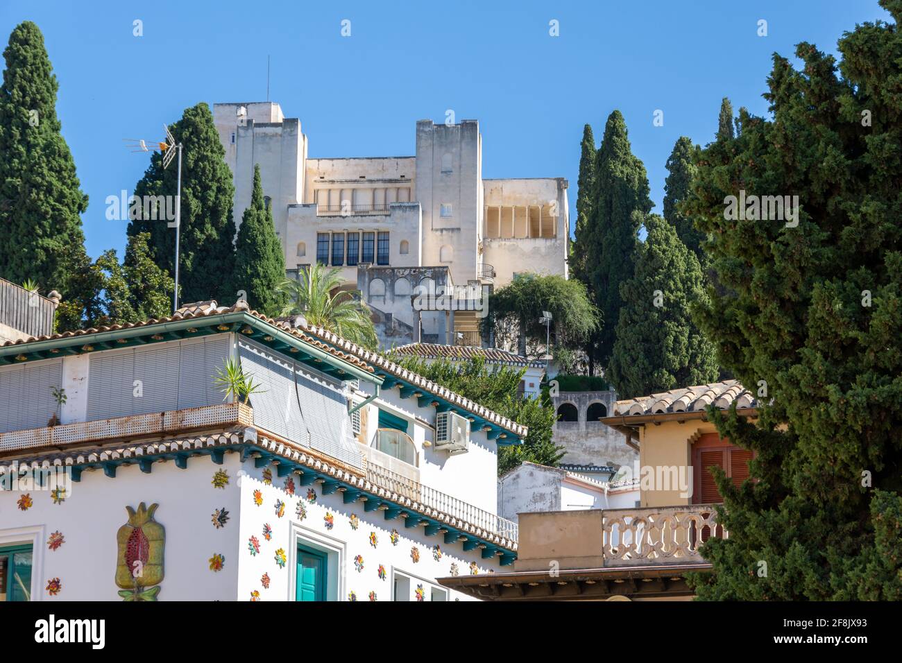 Facciata bianca di un vecchio ostello nel quartiere Realejo Di Granada (Spagna) decorata con molti soli in ceramica Foto Stock