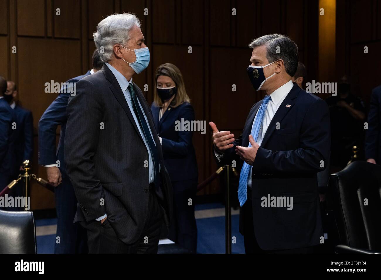 Christopher Wray, direttore dell'FBI, parla con William Burns, direttore della CIA, prima dell'inizio di una riunione del Comitato di intelligence del Senato, che ha udito le "minacce globali", a Capitol Hill, a Washington, mercoledì 14 aprile, 2021Crediti: Graeme Jennings/Pool via CNP /MediaPunch Foto Stock
