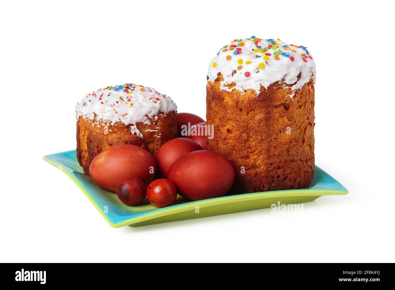 Torte pasquali festive e uova dipinte su un piatto isolato su sfondo bianco Foto Stock