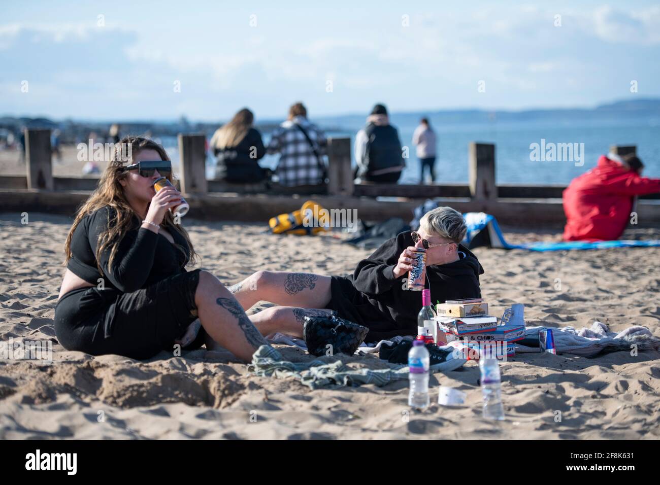 Edimburgo, Scozia, Regno Unito. 14 Apr 2021. NELLA FOTO: Le persone si divertono alla spiaggia di Portobello. La gente fuori godendo i cieli azzurri e il caldo tempo soleggiato sul lato orientale della Scozia a Portobello Beach. Credit: Colin Fisher/Alamy Live News Foto Stock