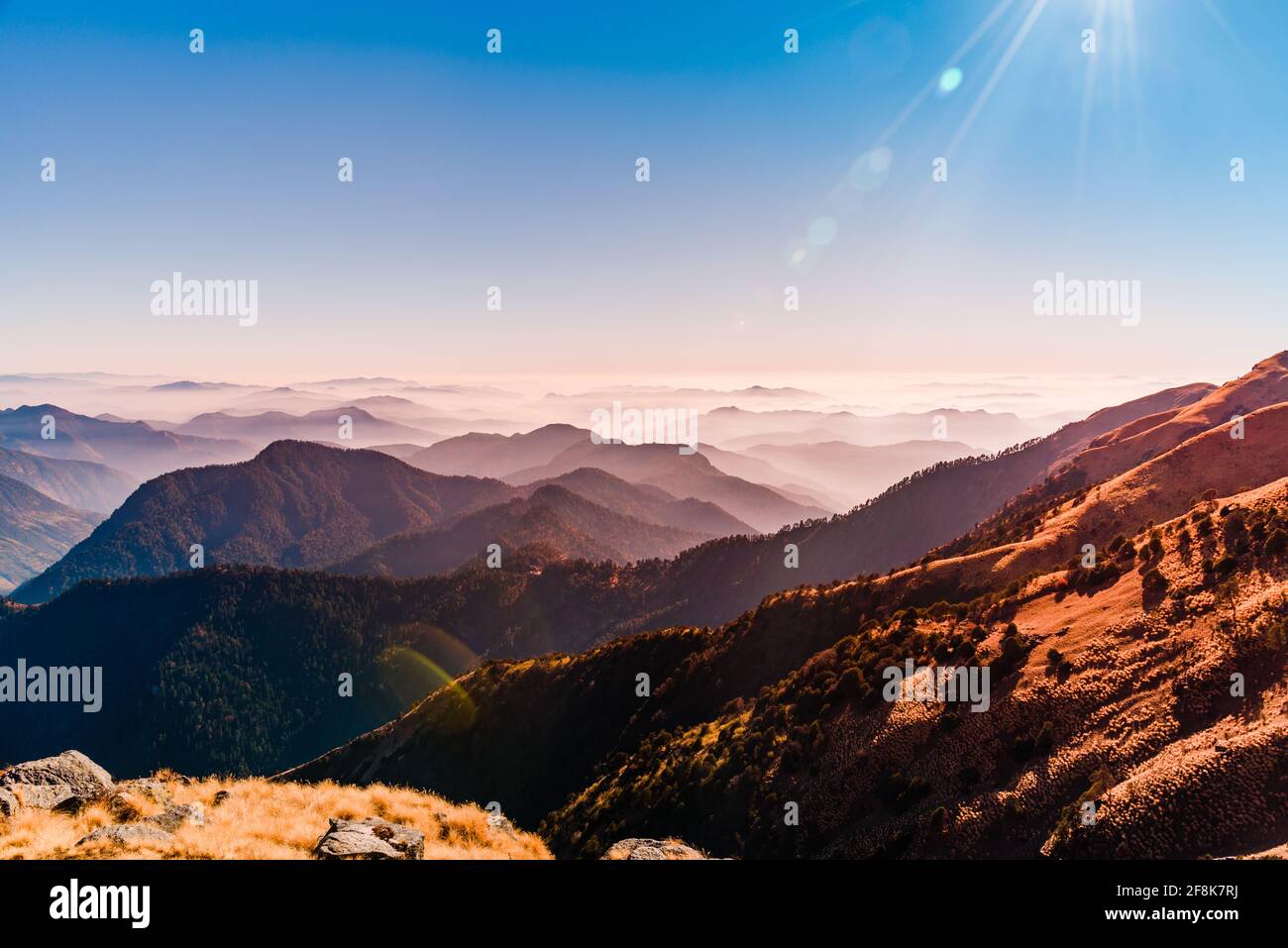 Vista della catena montuosa dell'Himalaya con silhouette visibili attraverso la colorata nebbia dalla cima del percorso di trekking Khalia. La cima Khalia si trova ad un'altitudine di 3500m h. Foto Stock