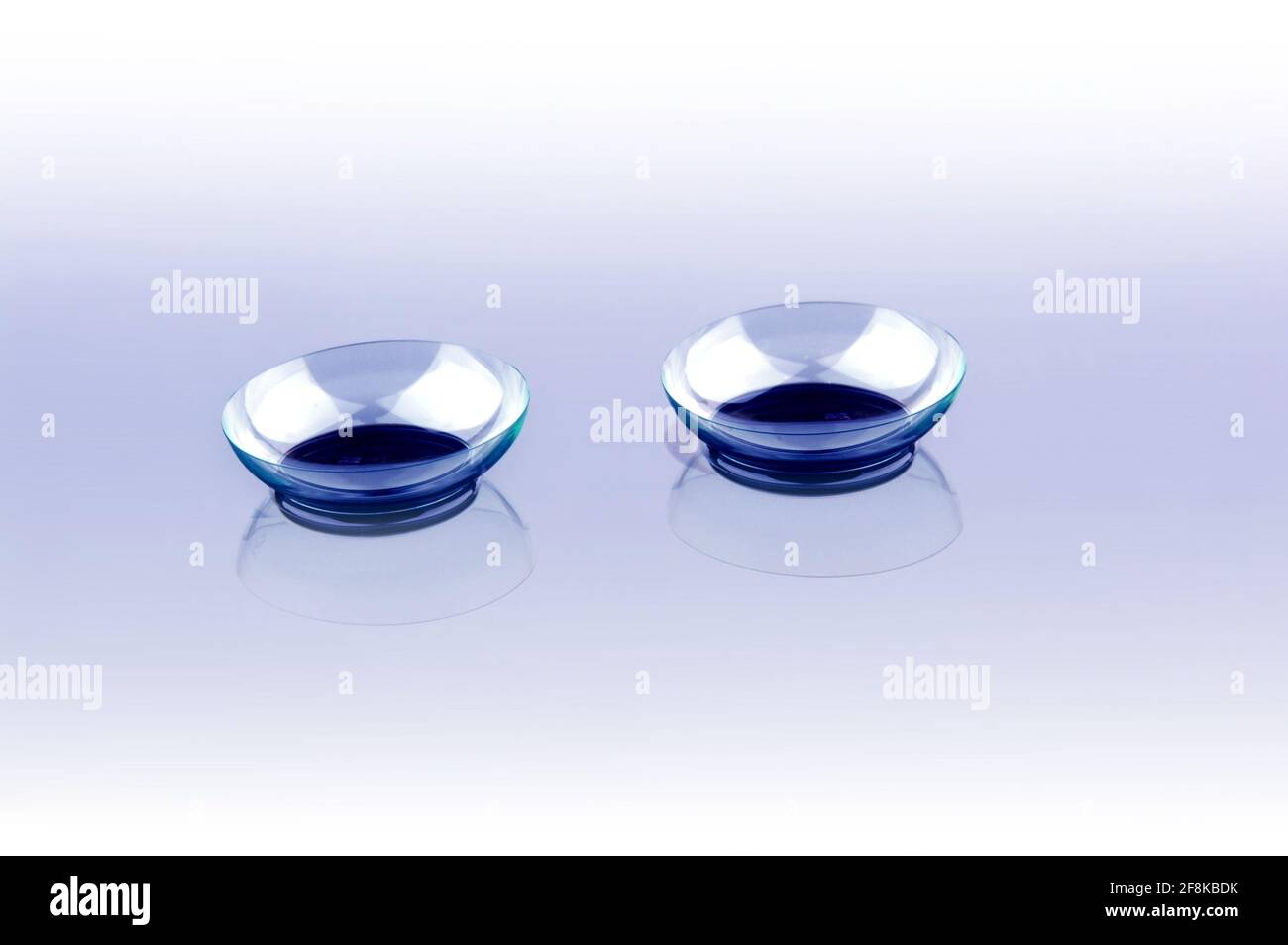 Due lenti a contatto con riflessi su sfondo blu Foto Stock