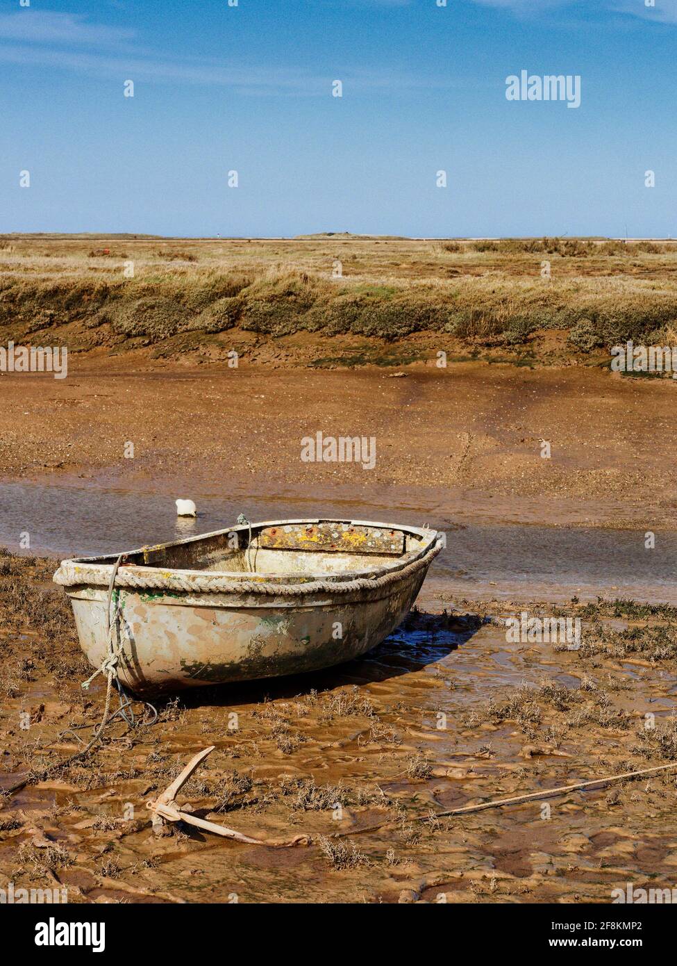 La bassa marea di Morston sulla costa nord del Noroflk lascia le barche bloccate sul fango appiccicoso della palude del sale. Foto Stock