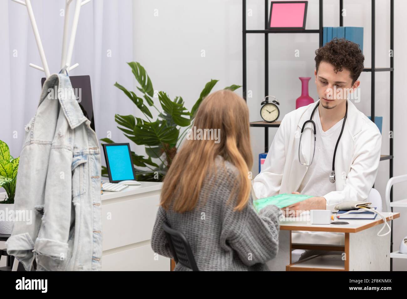 Il paziente fornisce le cartelle cliniche al medico di base. Studio medico Foto Stock